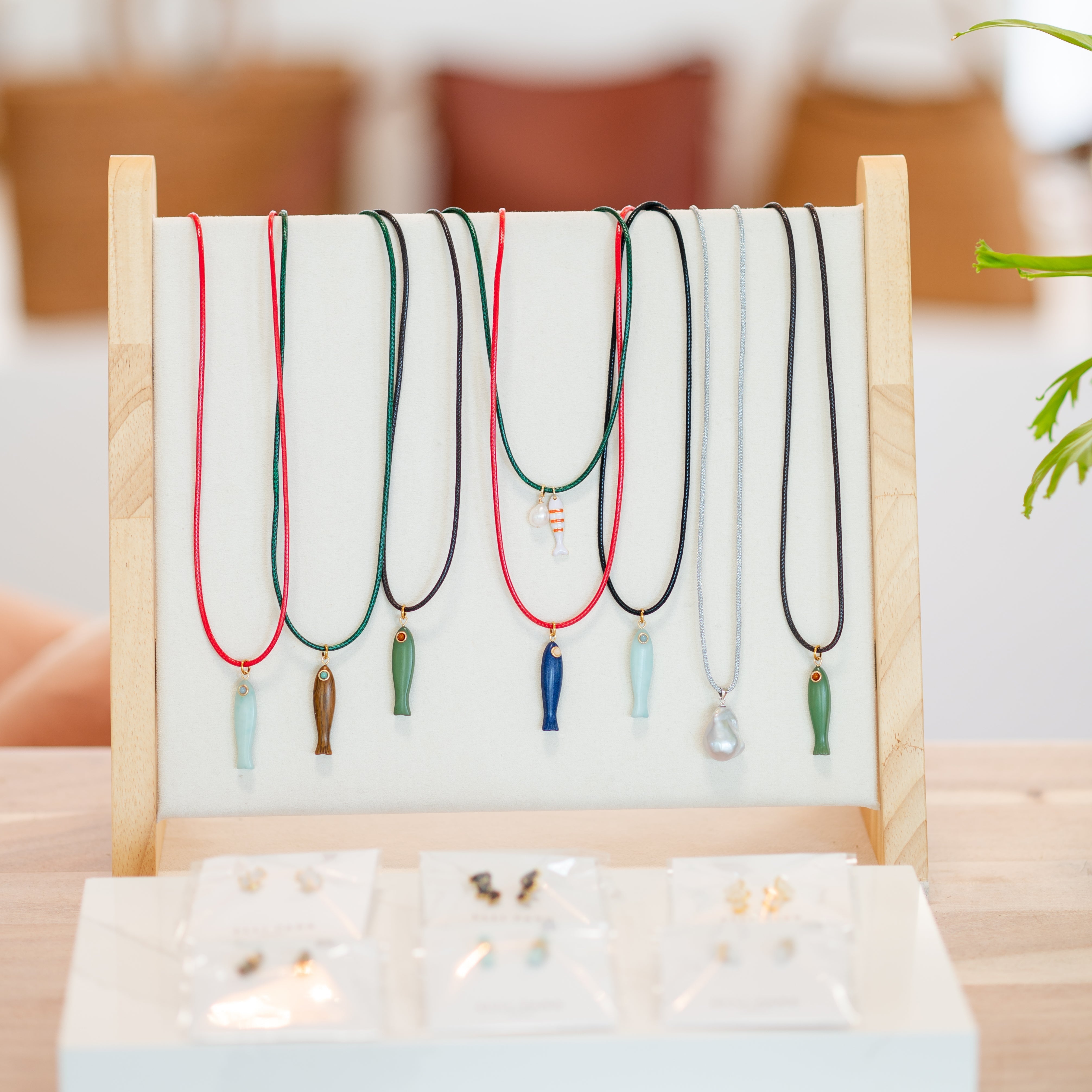 Woman wearing lapis lazuli fish necklace with red cord